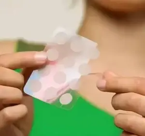 Woman showing how easy pick pimple patch perforated sheets Sigma Essentials Pimple Patches convenient application acne treatment professional skincare